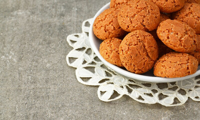 Traditional Italian almond cookies amaretti on a gray background with copy space.Famous amarettini cookie biscuits.Delicious Christmas pastry popular in Italy.Selective focus.