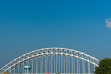 Fototapeta na wymiar arch shaped road bridge over the river canal