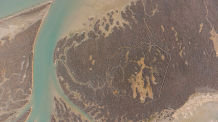 Aerial panorama of the Brussa lagoon, Veneto. Crystal clear and emerald water. Curved and circular shapes.