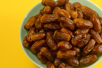 Dates. Dried date palm fruits. Healthy sweet snack food bowl. Pile of tasty dry dattes in plate....
