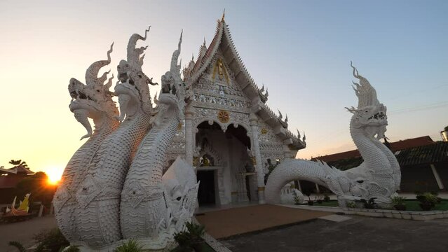 White Buddhist Temple Facade with Beautiful Dragon Statues in Northern Thai Lanna Style, High Quality 4K Slow Motion Religion Concept Footage. Thailand.
