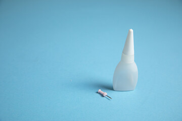 Bottle of glue on the blue background.
