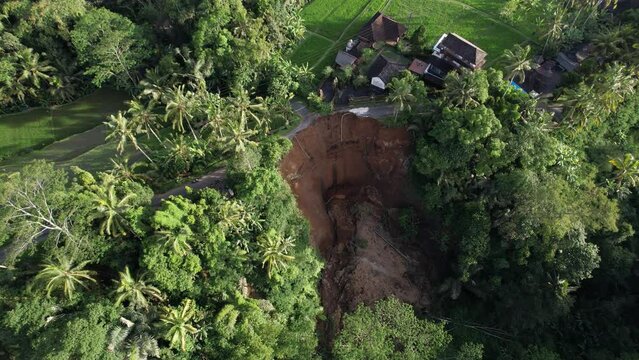 The landslide destroyed road above and left steep, dangerous and unstable precipice. Buildings stand at very edge and there is great risk of further collapse of ground. Consequences of heavy rains