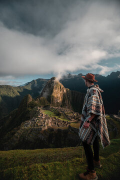 Vertical shot of a Caucasian hiker overlooking Machu Pichu in Peru