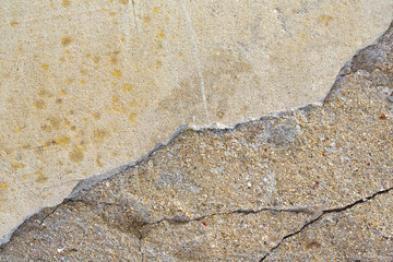 Deep crack in an old brick wall with damaged plaster