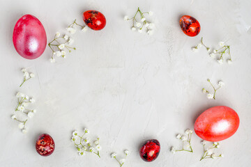 Banner. Easter frame with eggs and flowers on a white concrete background. Minimal concept. View from above. Card with copy space for text.