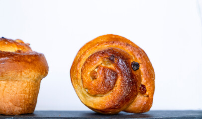 Two sweet Easter buns on a black stone surface and on a white background. Close up photo.