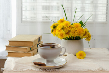 still life, bouquet of yellow wild flowers, tea with sweets, a book on the windowsill near the window and tea on the windowsill, tea party on vacation in summer