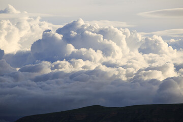 Beautiful white clouds on sky at dawn. Sunrise, stormy cloud. Cumulus clouds on mountain background, top view.