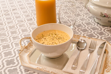 Fish soup served in a dish with juice on a tablecloth.