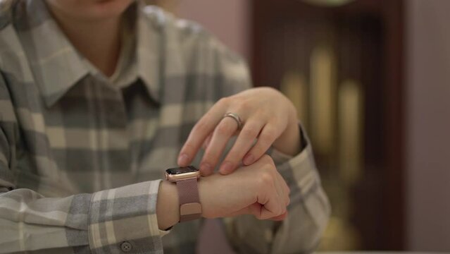 Woman using touch screen smart watch on a female wrist