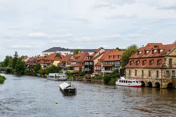 Obraz premium Boats on the River Regnitz with the historic buildings of the old Bamberg town in Germany