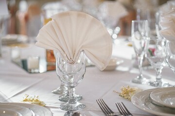 Closeup shot of a glass with a folded cloth on a wedding table