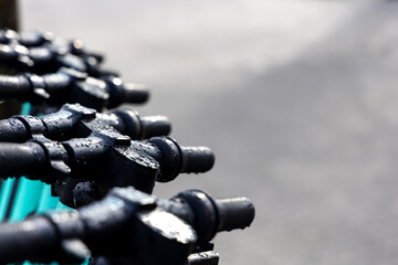 Wet handle bars of the electric scooters. Electric scooters standing in the rain on the street.