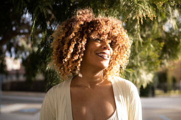 beautiful afro dominican woman laughind during sunset - obrazy, fototapety, plakaty