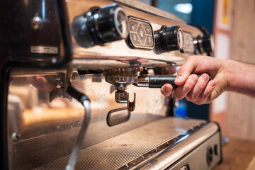 Fototapeta na wymiar Hand in the coffee machine of a bar