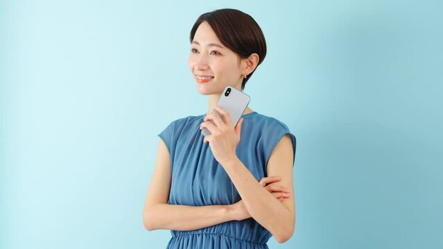 スマートフォンを使うワンピースを着た若い女性