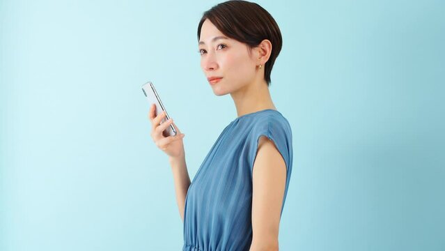 スマートフォンを使うワンピースを着た若い女性
