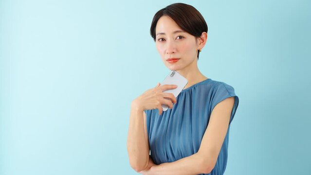 スマートフォンを使うワンピースを着た若い女性
