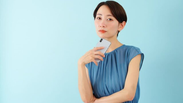 スマートフォンを使うワンピースを着た若い女性
