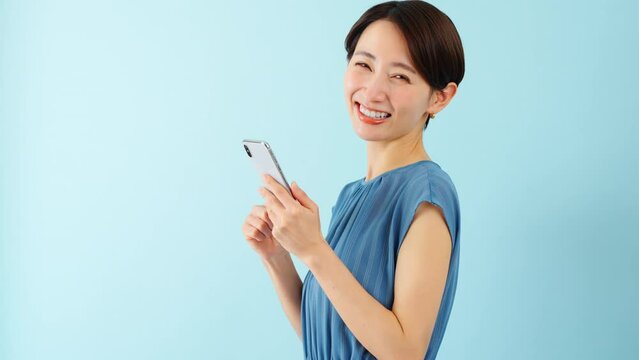 スマートフォンを使うワンピースを着た若い女性