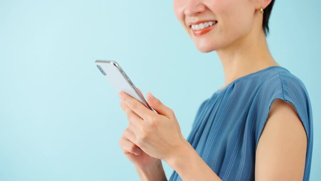 スマートフォンを使うワンピースを着た若い女性