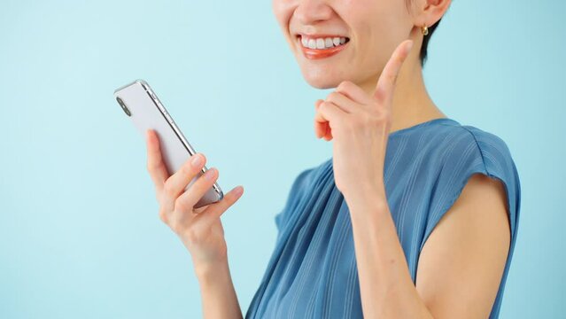 スマートフォンを使うワンピースを着た若い女性