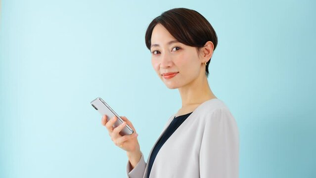 スマートフォンを使う若い女性　ビジネスイメージ