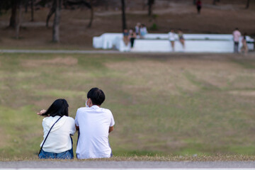 Young couple sitting watching sunset in evening and chatting happily. young couple sits and talks to discuss and express their hearts to each other. concept of love and friendship for each other.