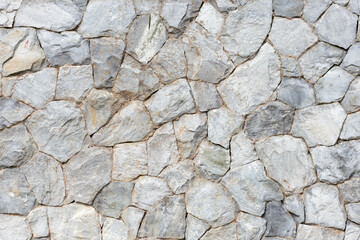 The stone wall background that was constructed from natural stones and arranged to be beautiful, strong and have a natural surface, making the stone wall popular with people. background and copy space