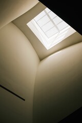 Vertical of an interior of a modern beige building with a glass ceiling