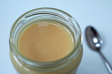 Top view of open jar of set honey with spoon.