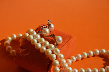 pearl jewelry, beads around the neck, a gold ring with pearls and earrings. women's necklace. background for the design.