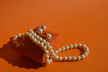 pearl jewelry, beads around the neck, a gold ring with pearls and earrings. women's necklace. background for the design.
