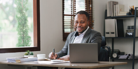Smiling American African makes financial report and studies annual figures, analyzes profits. Accountant checks status of financial