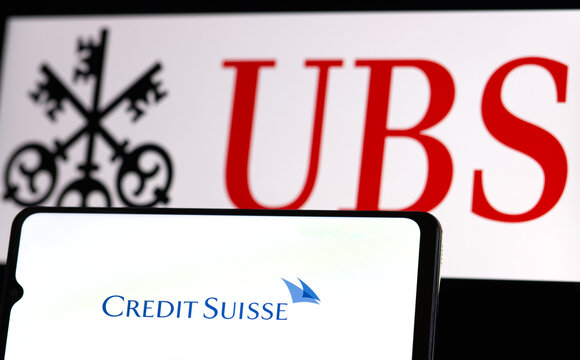 Smartphone with Credit Suisse Bank logo on background of UBS Bank and Group symbol, Switzerland, March 18, 2023 