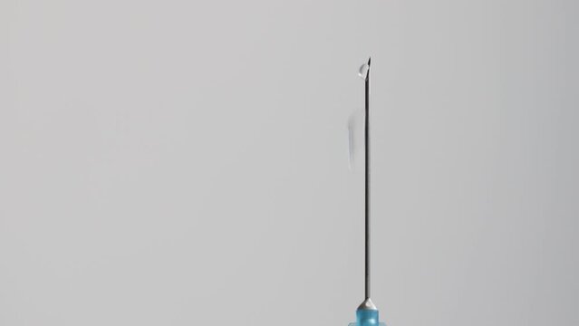 medicine pouring out of the needle of a medical syringe