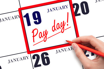 Hand writing text PAY DATE on calendar date January 19 and underline it. Payment due date