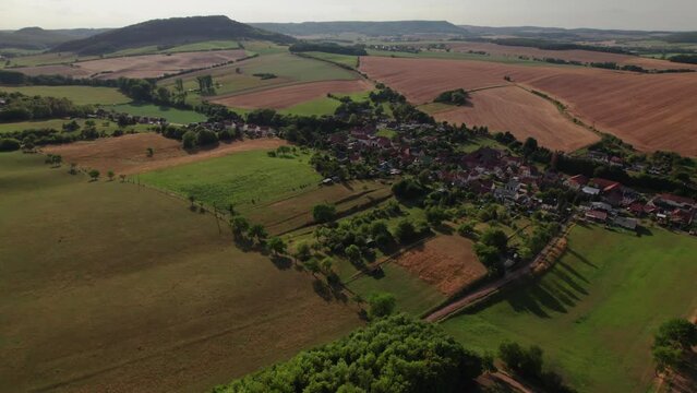 Aer ial view of a German village surrounded by meadows, farmland and forest in Germany.