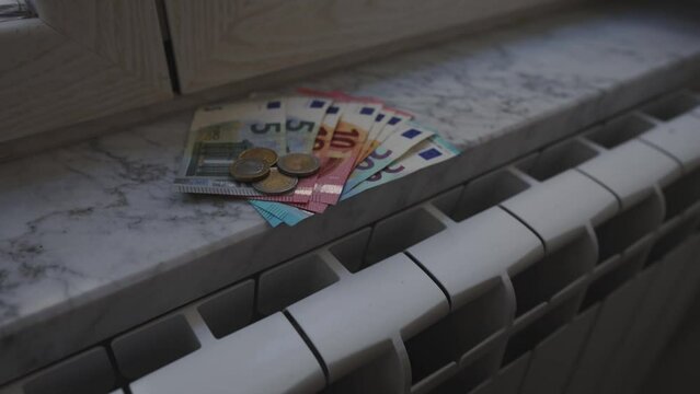 Concept of expensive heating payments. Money on the radiator.