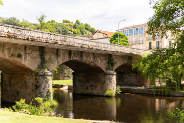 Crossing the serene waters of the Avia River, the historic stone bridge in Ribadavia, Galicia exudes rustic charm