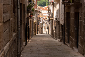 Obraz premium The narrow and winding old streets of Galicia, Spain, lined with historic architecture and cobbled paths, offer a glimpse into the region's rich history and culture