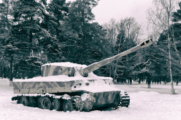 A snow-covered tank in a faded camouflage in the forest