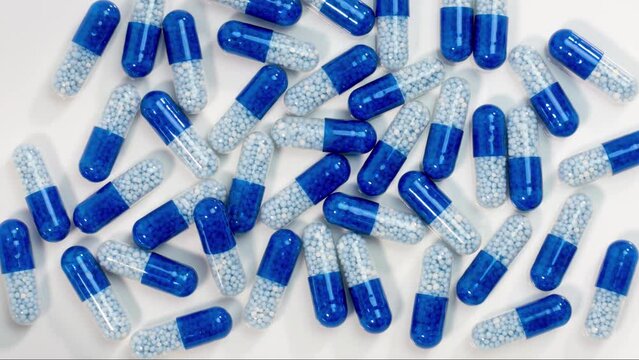 Medicine, close-up focus blue medical capsules and one yellow on white background HD stop motion animation