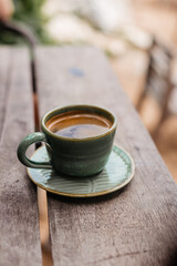 Sturdy Americano for breakfast on a wooden table. Delicious hot coffee on the veranda.