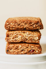 Three protein cookies on a white plate on a light background. Stylish concept of nut snack. Delicious dietary dessert