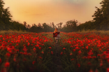 
girl runs into the sunset across the poppy field