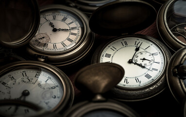 A collection of antique pocket watches with various times shown, creating a textured pattern of timepieces.