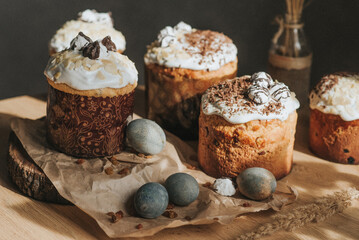 Traditional christian easter cake with white swiss meringue on table. Homemade cruffin cake and colorful painted eggs. Homemade food. Rustic