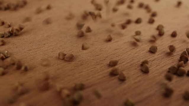 buckwheat groats close-up slowly pouring on the table background food video for cooking